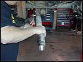 RE8003 Removing the left rear shock.