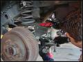 RE8003 Remove the lower rear track bar dust cover.