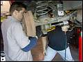 RE8003 Removing left rear lower control arm from axle.